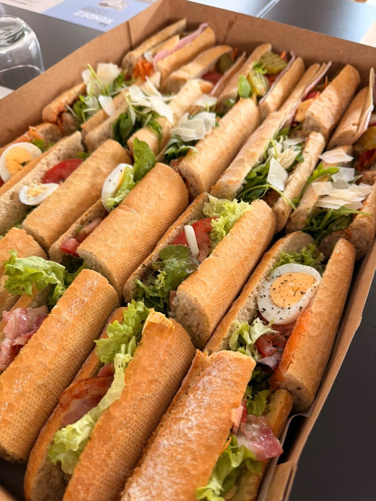 Des baguettes garnies serrées dans leur plateau de transport.