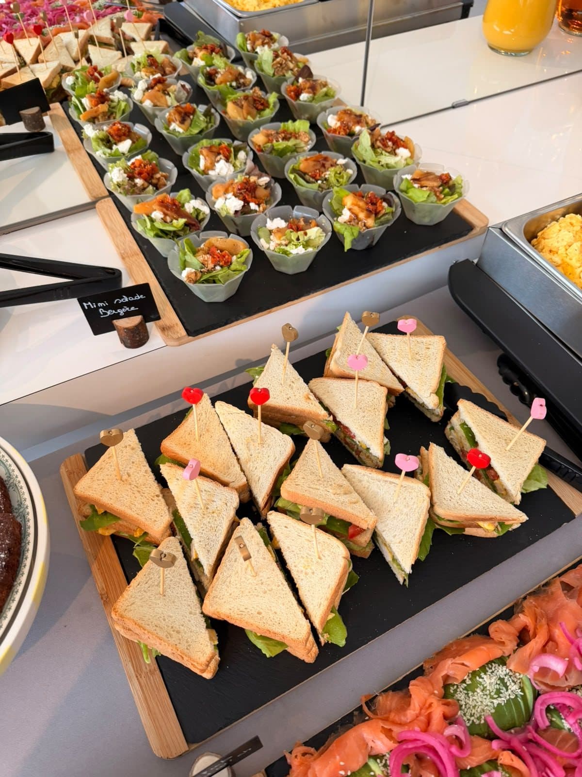 Un plateau de club sandwichs coupés en triangles et de canapés garnis.